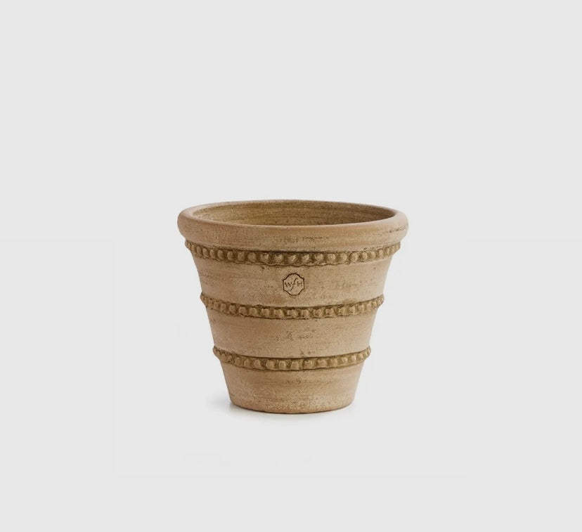 A beige, round ceramic pot with triple beaded detailing, designed by Peter Wakefield.