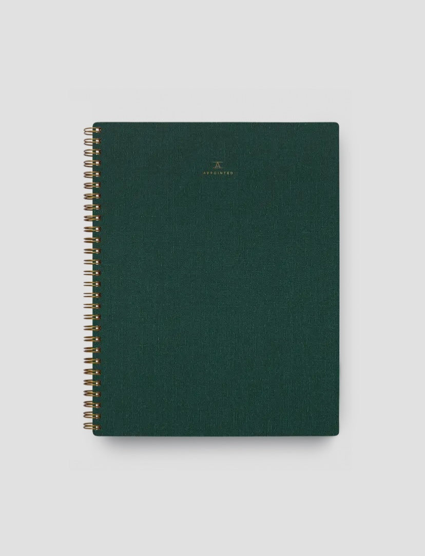 A Hunter Green Apppointed notebook with brass wire-o binding and a smooth cotton bookcloth cover.