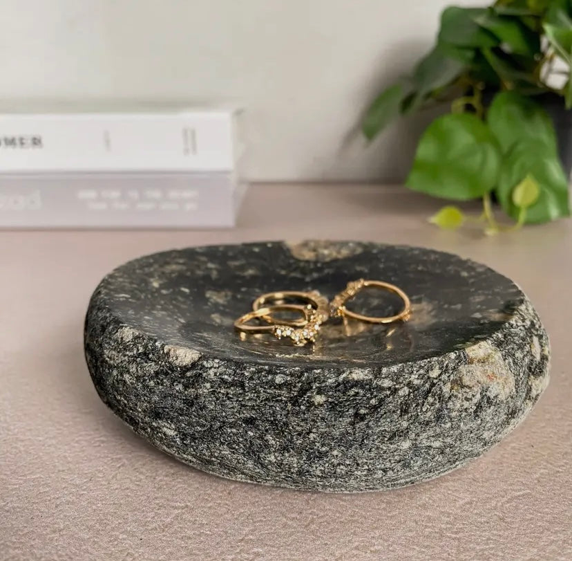 Black and white beach stone dish holding jewelry.