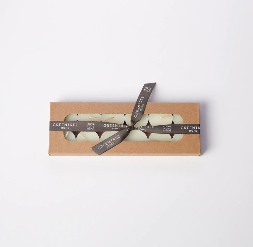 A set of beeswax tea lights candles in a cardboard box with a branded label, tied with a ribbon by Greentree Home