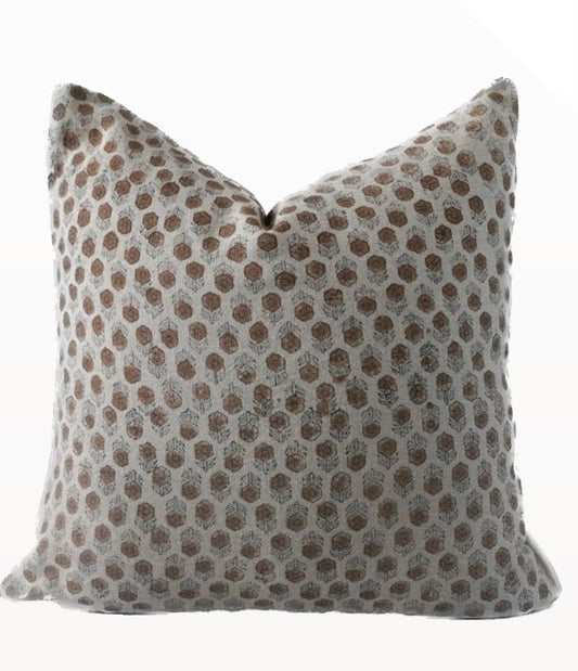A beige and brown geometric patterned pillow cover with a zipper closure.