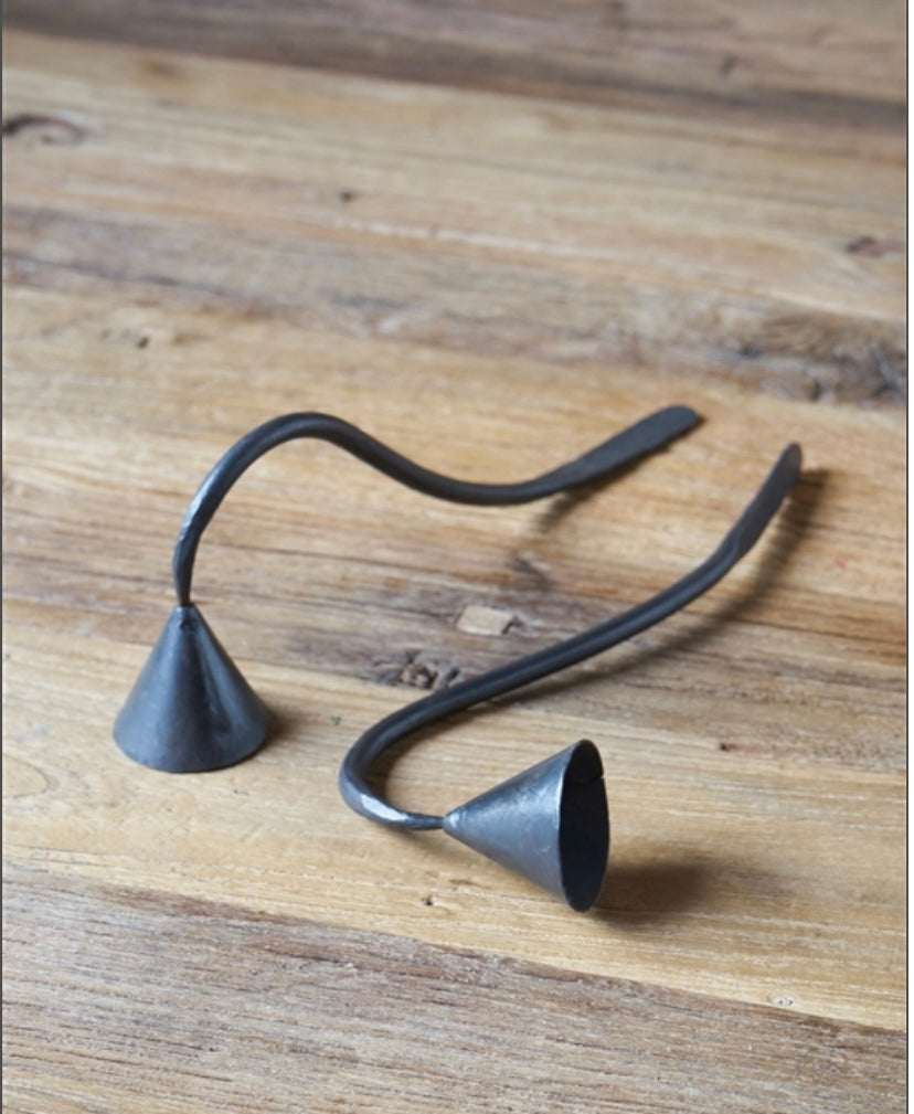 Two Iron Candle Snuffers on wooden table.