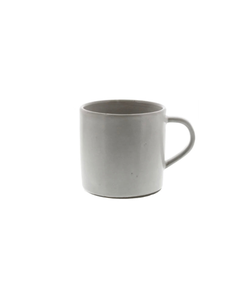 A beige ceramic mug with a handle, dipped in a white glaze.