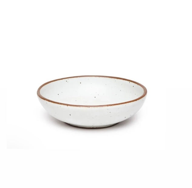 An eggshell ceramic serving bowl with a brown rim and speckled texture.