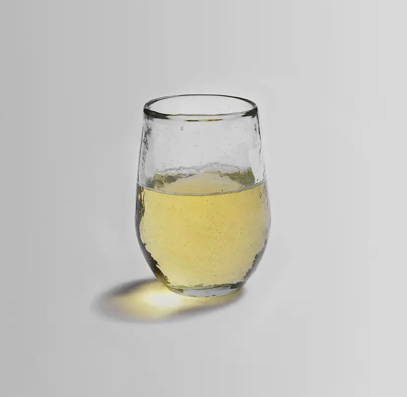 Handblown glass with pebbled texture filled with white wine.