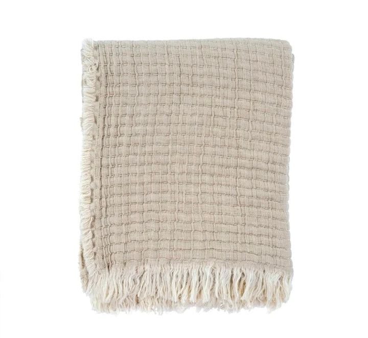 A beige Kantha Stitch Throw with fringed ends on a white background, showcasing the texture and craftsmanship of the hand-stitched kantha stitching.