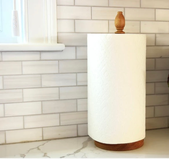 Oak paper towel holder with roll on kitchen counter.
