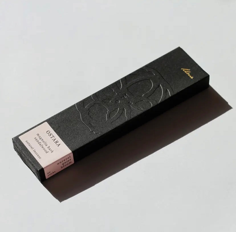 A box of OSTARA incense sticks with magnolia design, alongside a label showing the brand name and the scent 'Magnolia Bark & Sandalwood'.