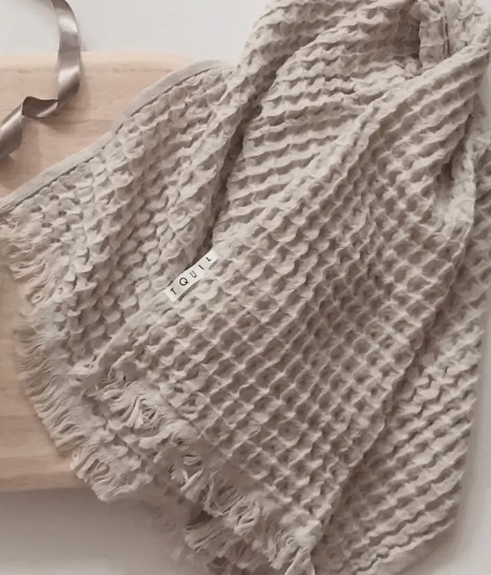 Textured gray waffle towel on a wooden surface
