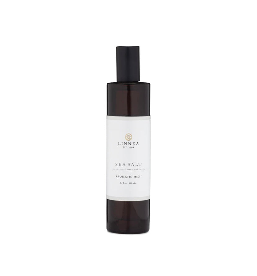 A brown bottle of LINNEA sea salt aromatic mist room fragrance spray with a white label and black cap.