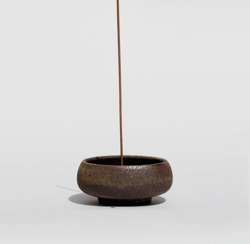 Wabi sabi incense bowl shown from the side on white background.