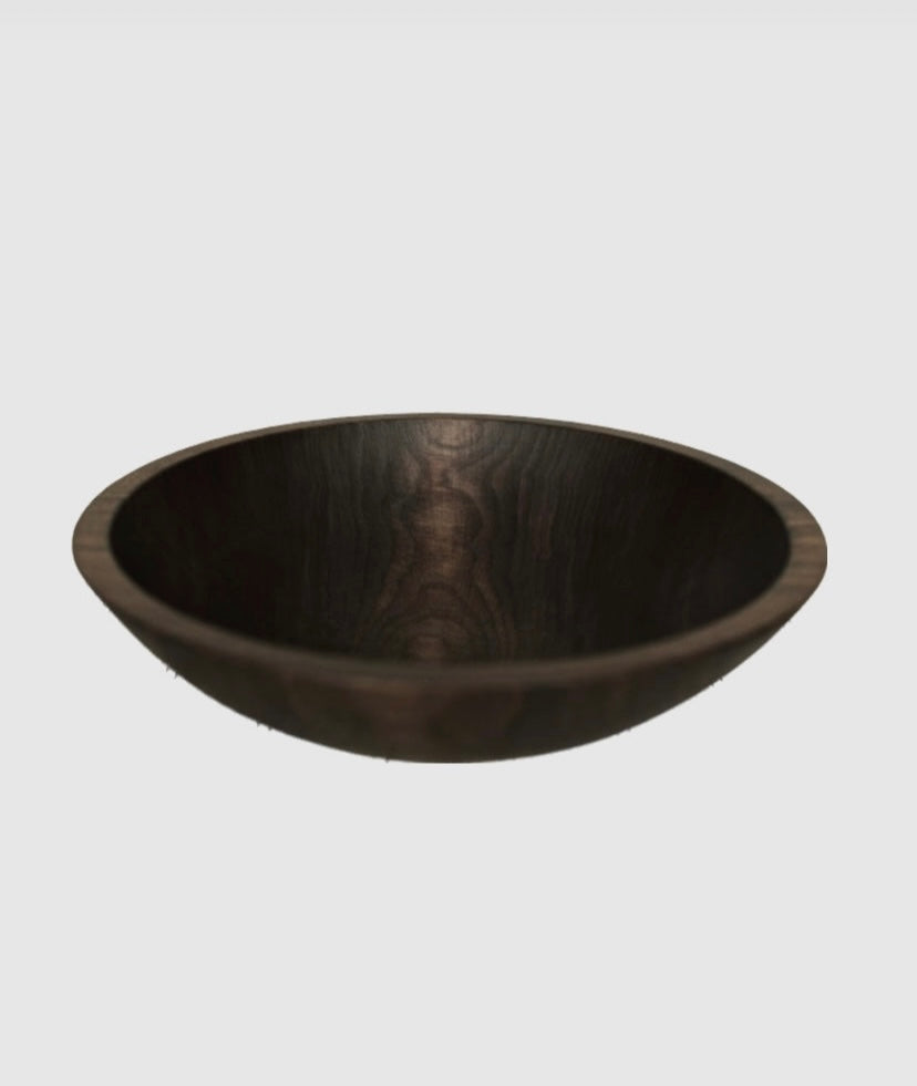 A natural solid walnut serving bowl, not stained but finished with bee's oil, with a wood grain that varies. Intended for serving salads or as a fruit bowl.