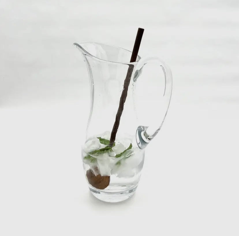 Walnut stirring spoon in glass pitcher.