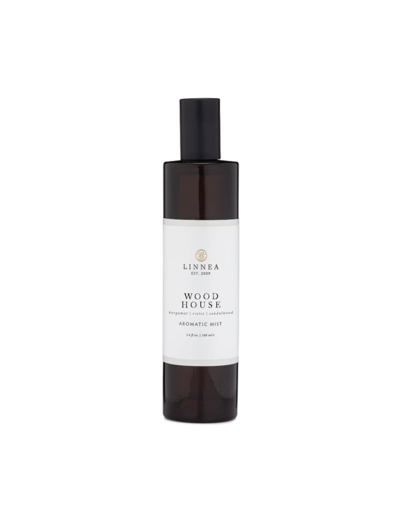 A white spray bottle with a black cap labeled 'Wood House Aromatic Mist LINNEA' on a plain background.