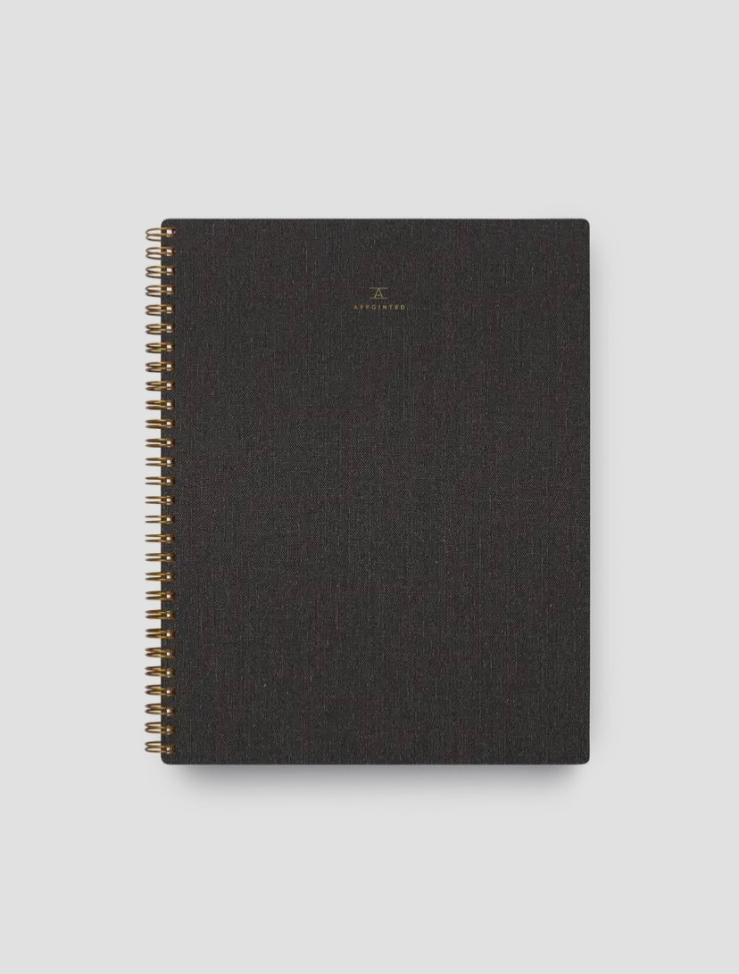 A Charcoal Gray Apppointed notebook with brass wire-o binding and a smooth cotton bookcloth cover.