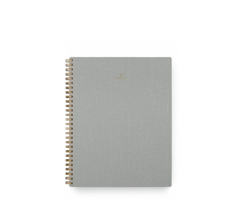 A gray Apppointed notebook with brass wire-o binding and a smooth cotton bookcloth cover.