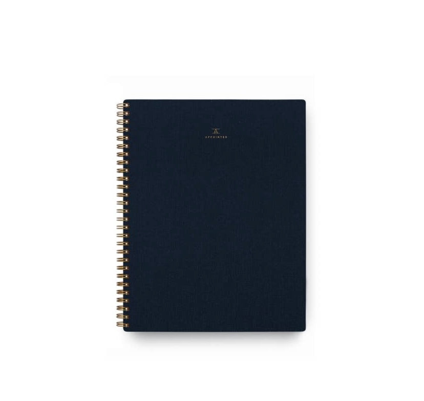An Oxford Blue Apppointed notebook with brass wire-o binding and a smooth cotton bookcloth cover.