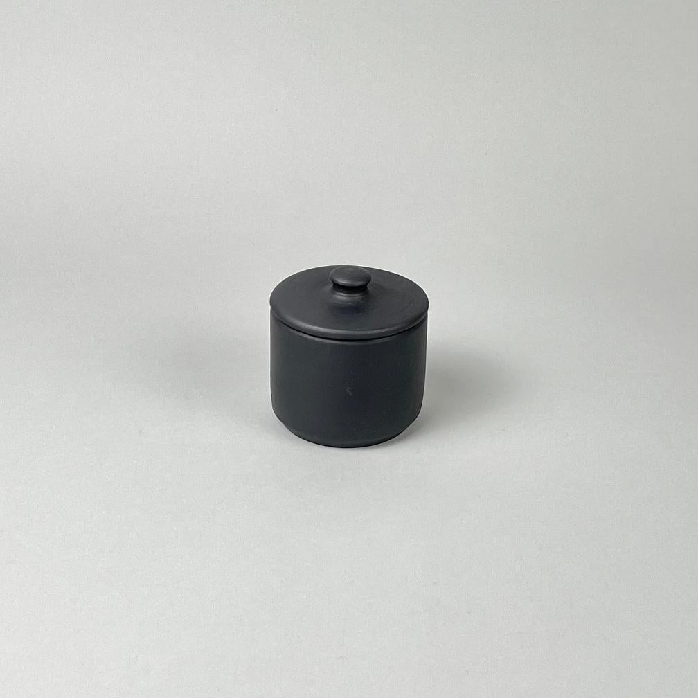 A matte black lidded sugar jar with a minimalist design, placed against a neutral background.