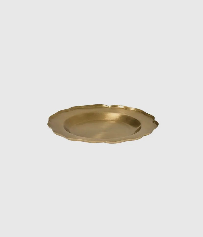 A round brass tray with scalloped edges on a white background.