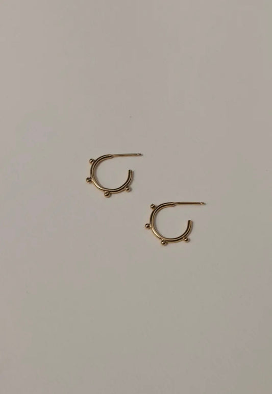 Gold hoop earrings on a light gray background