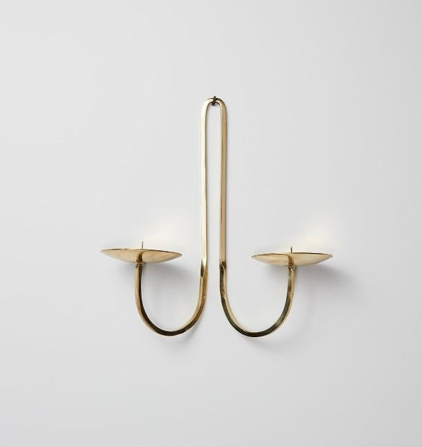 Brass U-shaped candle holder on a light gray background