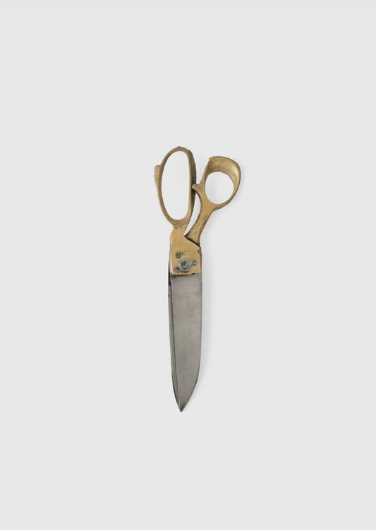 Handcrafted gold-handled scissors with a silver blade on a white background