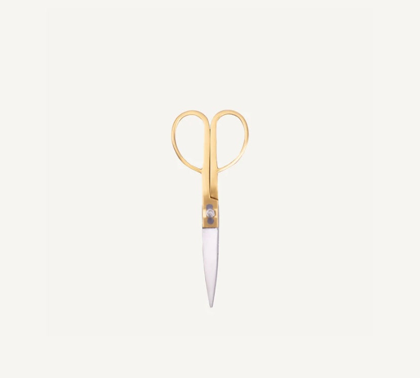 Gold-handled scissors on a light gray background