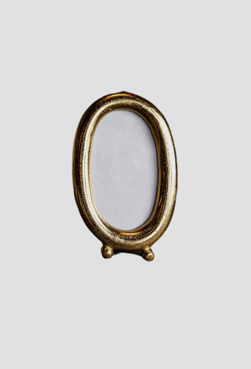 Small oval brushed gold frame.
