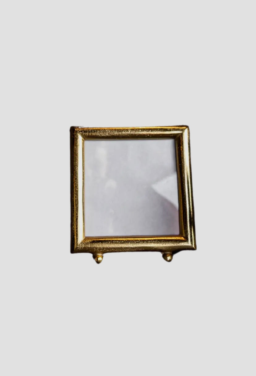 Brushed gold square frame on a light gray background