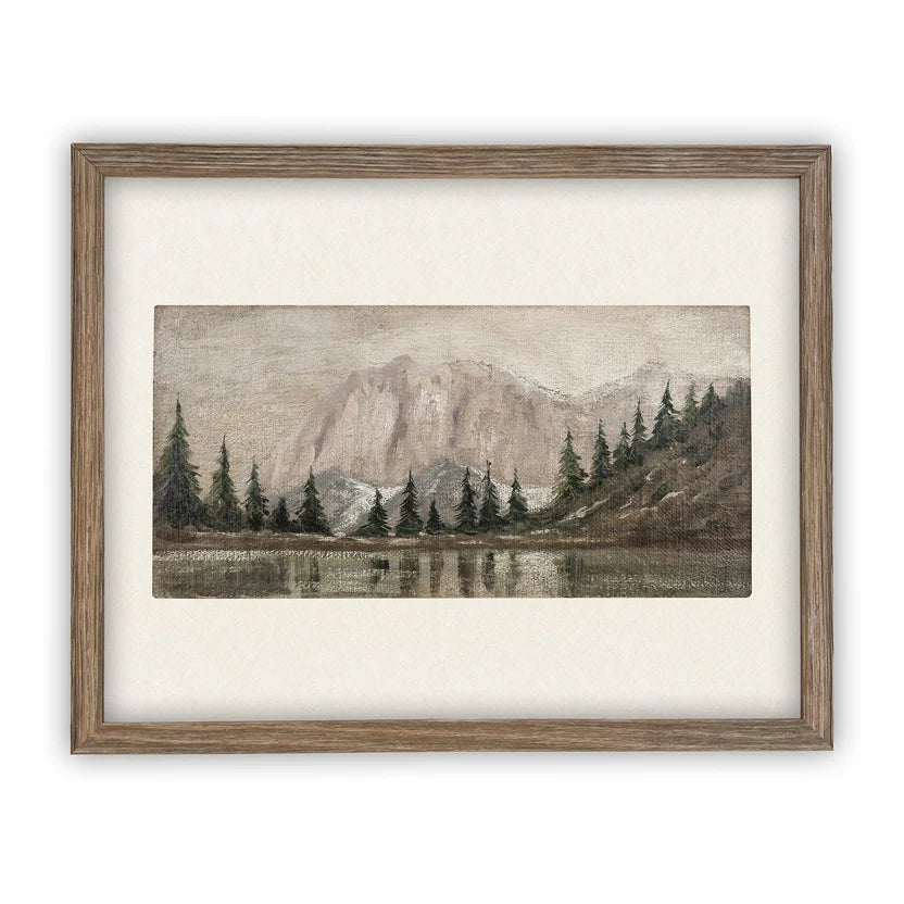Framed artwork of a mountain landscape with trees and water in foreground
