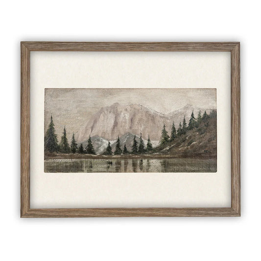 Framed artwork of a mountain landscape with trees and water in foreground
