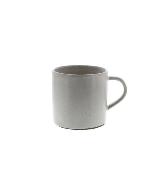 A beige ceramic mug with a handle, dipped in a white glaze.