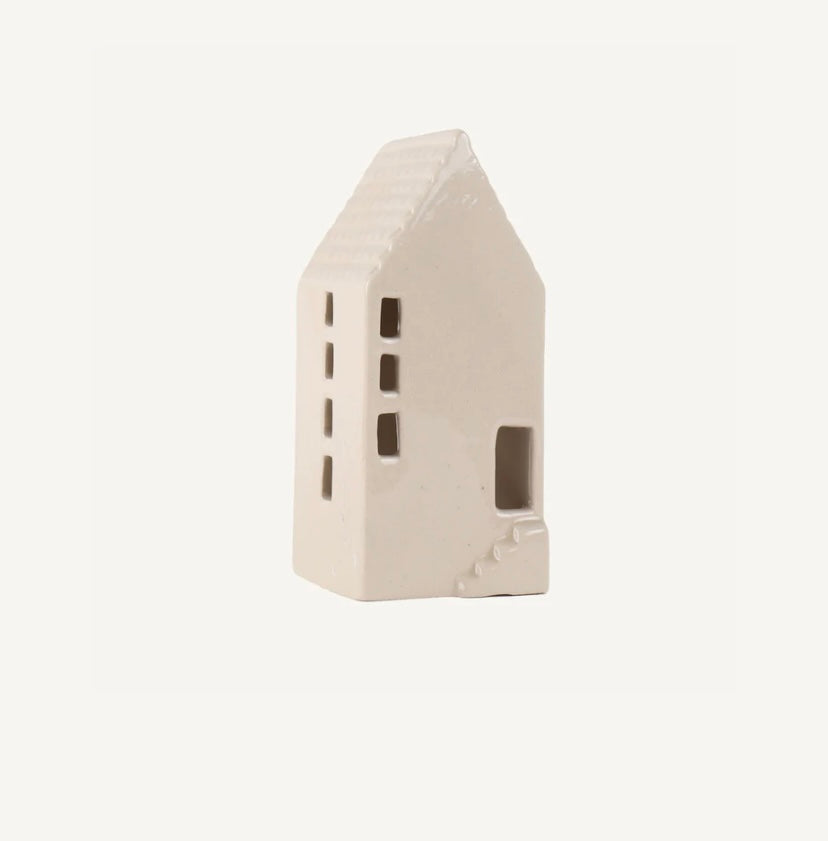 Taller white ceramic house on a light beige background