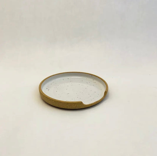 Round ceramic dish with speckled design on a white background by m.bueno