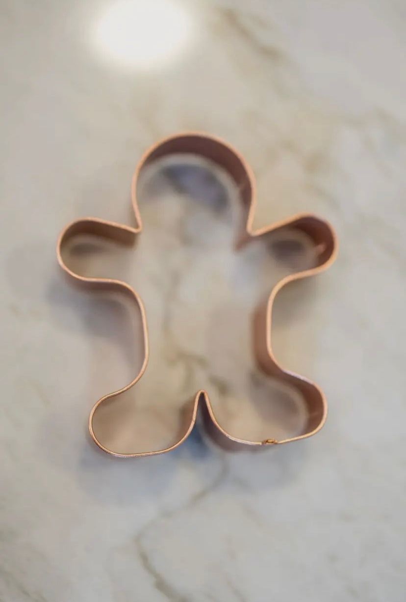 Gingerbread man cookie cutter on a marble surface
