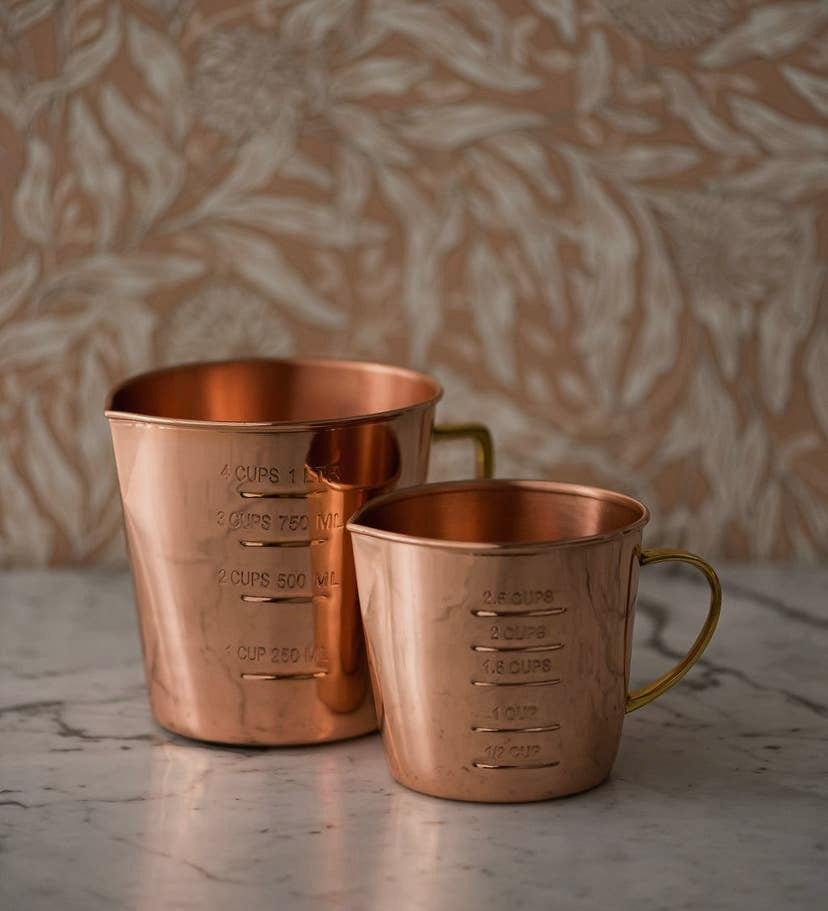 Coper measuring cups on counter.