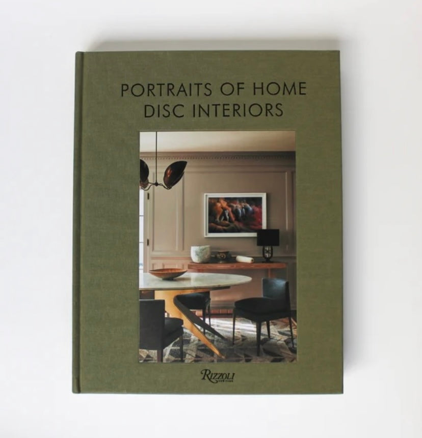 A green hardcover book titled 'Portraits of Home Disc Interiors' showcasing an interior photograph of a modern living room on the cover.