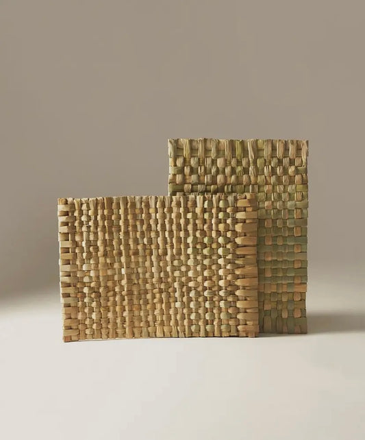 Two handwoven placemats with a textured pattern.