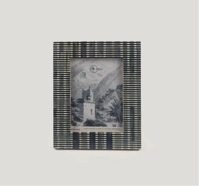 Striped photo frame with a black and white image inside on a light gray background