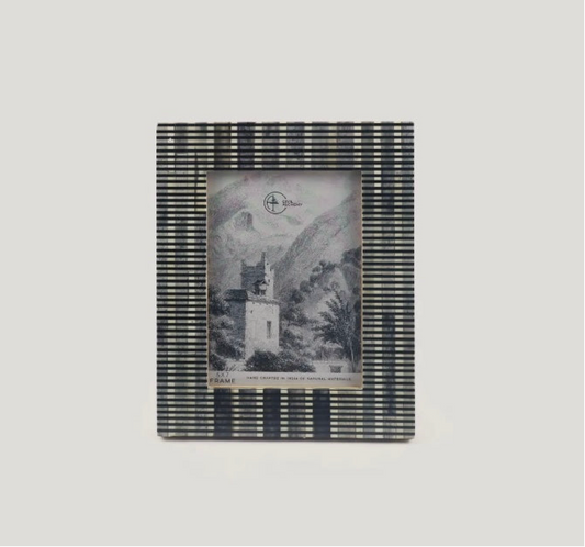 Striped photo frame with a black and white image inside on a light gray background