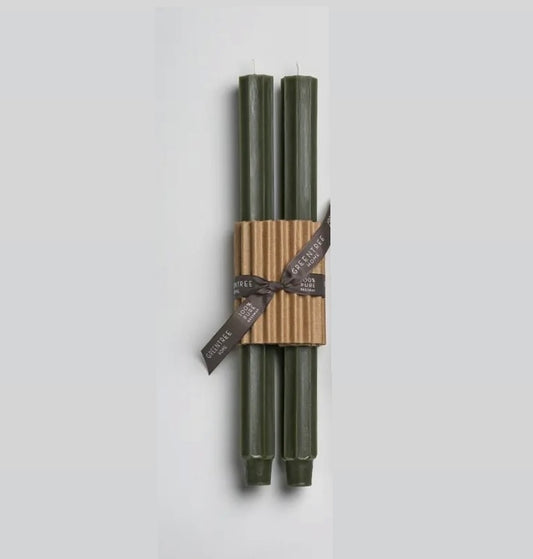 A pair of green fluted taper candles tied together with a brown band and decorative ribbon, set against a white background.