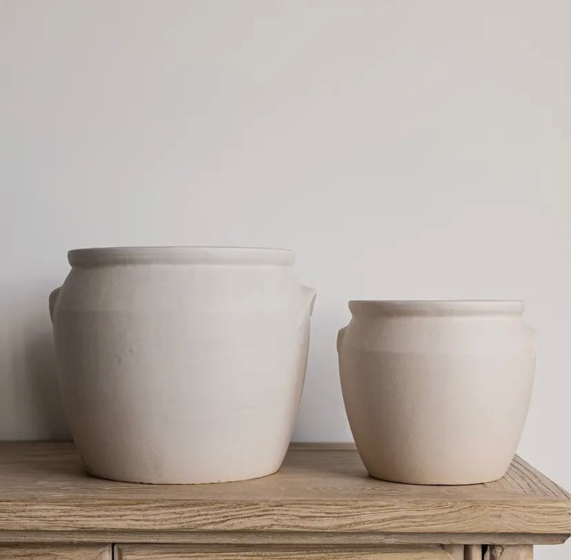 Two sizes of ceramic confit pots on a wooden table
