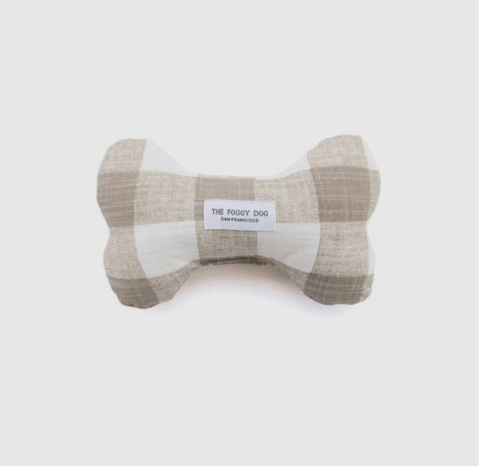 A beige dog bone-shaped toy with a gingham pattern, labeled 'The Roovy Dog' on the side.