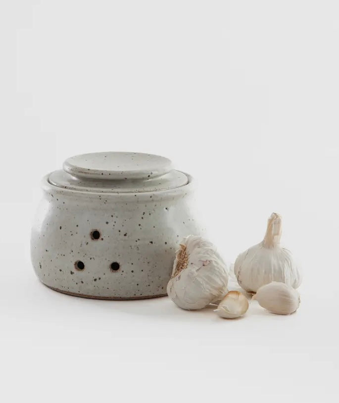 Speckled gray garlic keeper with bulbs on a white background