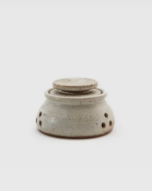 Speckled gray ceramic oil burner on a white background