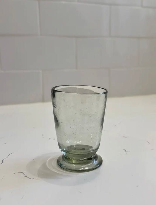 Clear glass on a white surface with a tiled wall background
