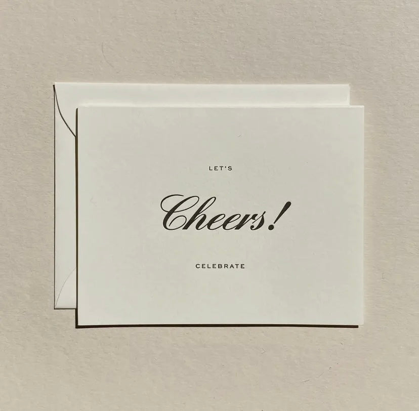 Greeting card with 'Let's Celebrate- Cheers!' text on a beige background