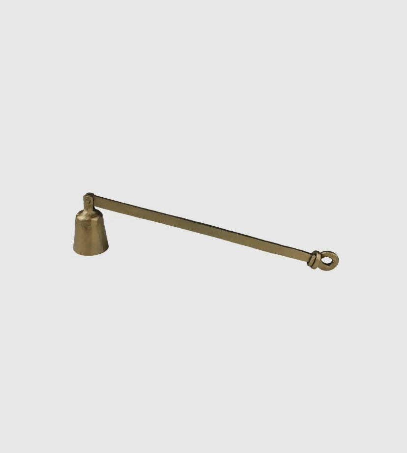 Brass candle snuffer on a light gray background