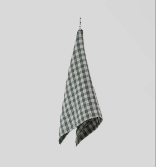 Checkered towel hanging on a hook against a light gray background