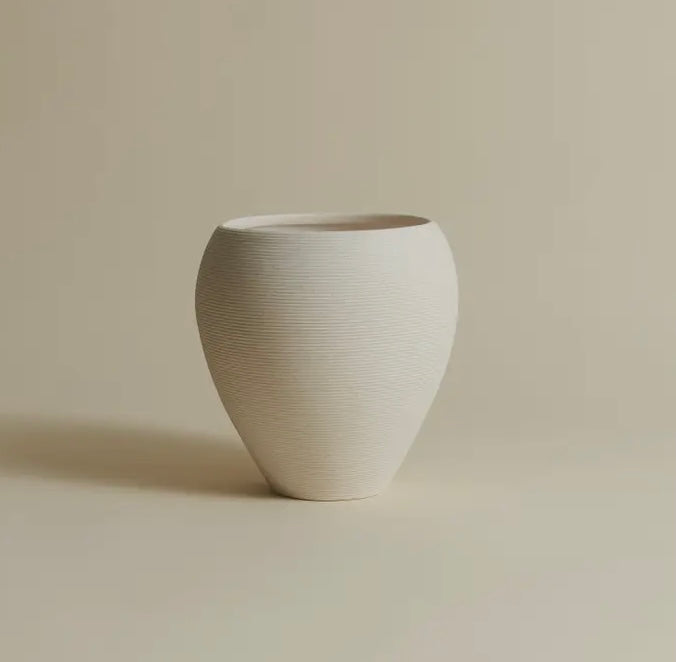 White ceramic vase on a beige background